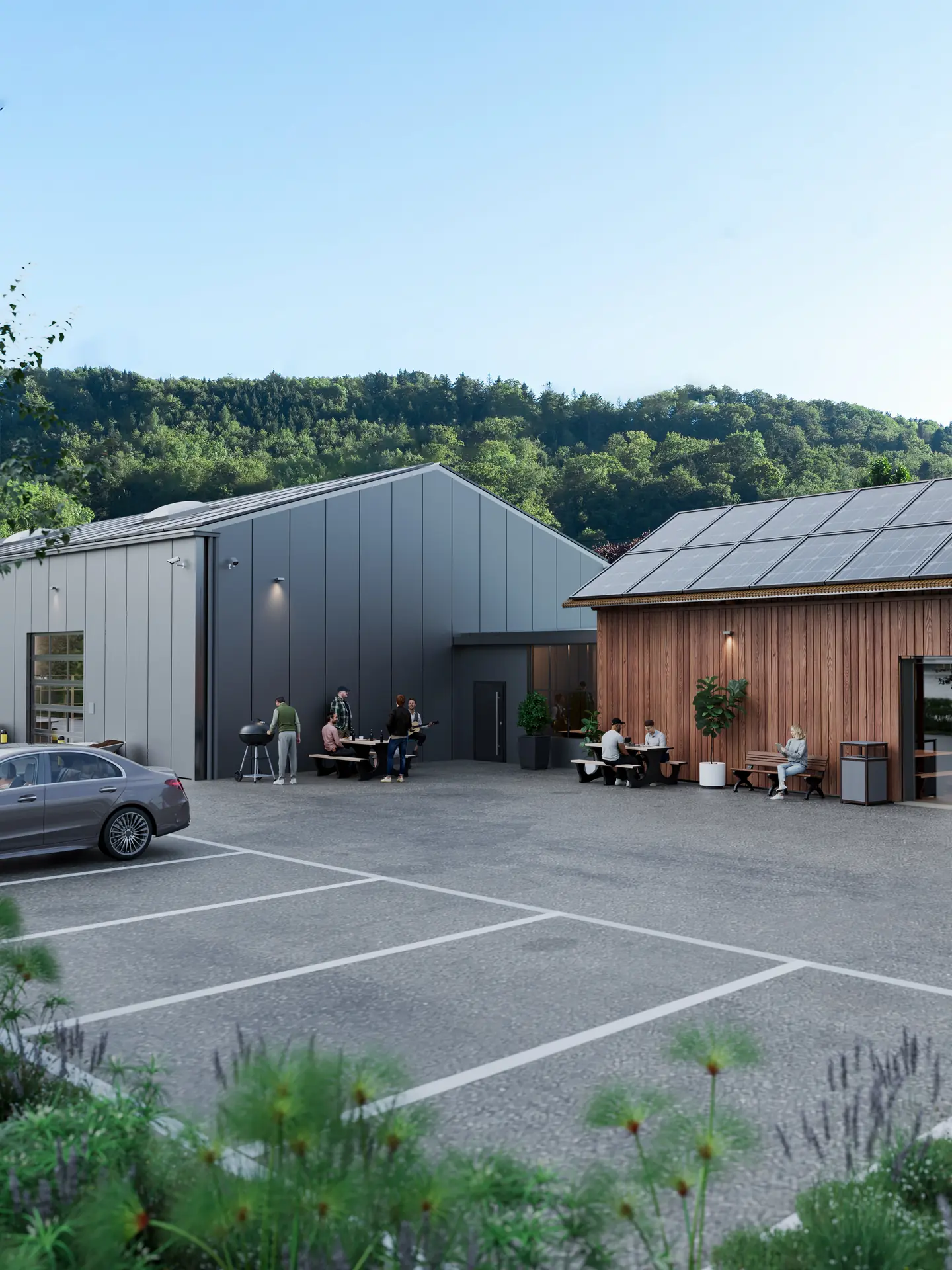 Hof zwischen Halle und Güterschopf mit Sitzbänken, Grill und den Parkfeldern im Vordergrund